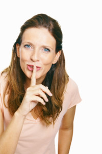 Keeping a secret - Portrait of a mature women holding a finger on her lips
